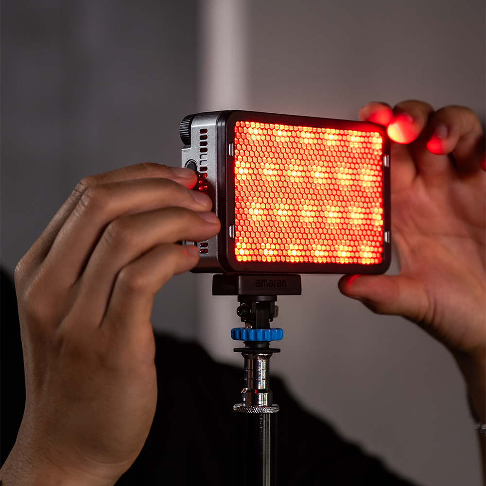 amaran Ace 25c Charcoal held on a light stand, outputting saturated red
