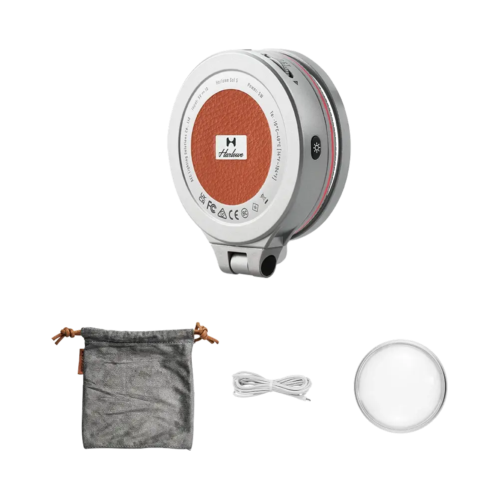 Harlowe Sol 5 XM light: silver body, orange center logo, pouch, cable, diffuser. Mobile photography accessory.