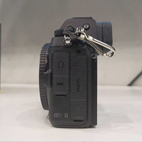 Camera body with lens cap on a white surface, Z 7 II box in the background