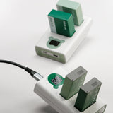 Two Tilta TBC-E17 LP-E17 dual chargers in Ash Green and Forest Green charging TLP-E17 batteries over USB-C