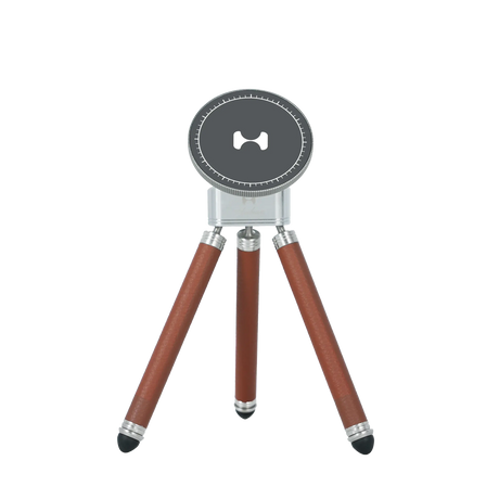 Compact MagSafe tabletop tripod with dark grey magnetic top, brown leather-textured legs, and silver adjustable mounting hardware for mobile content creators.