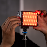 amaran Ace 25c Charcoal held on a light stand, outputting saturated red